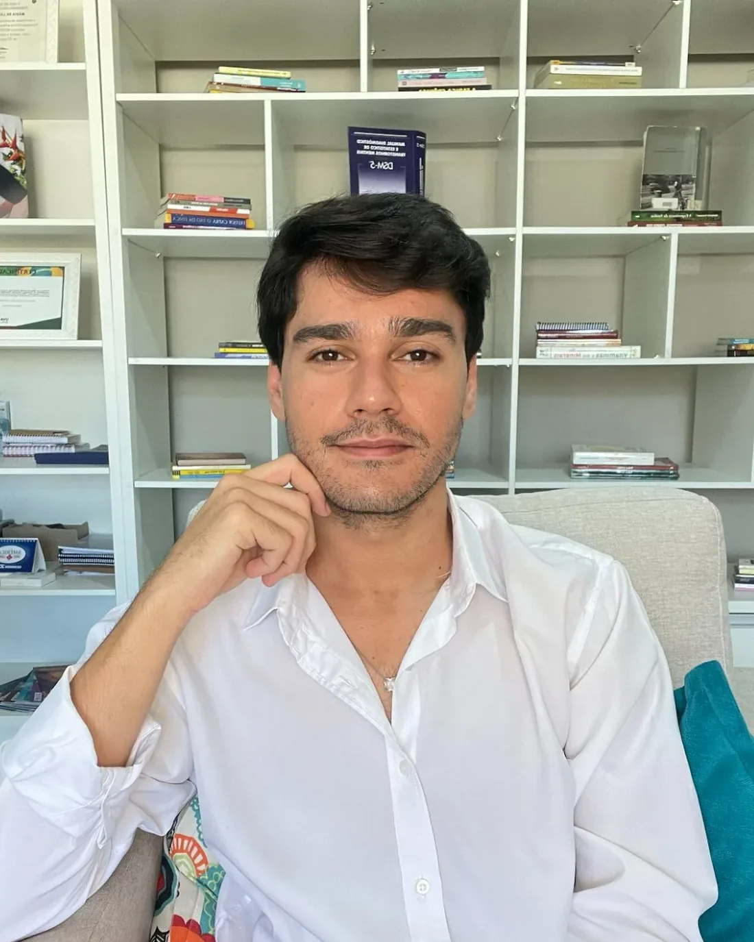 Steve Quadros Cardoso, psicólogo, sentado no consultório